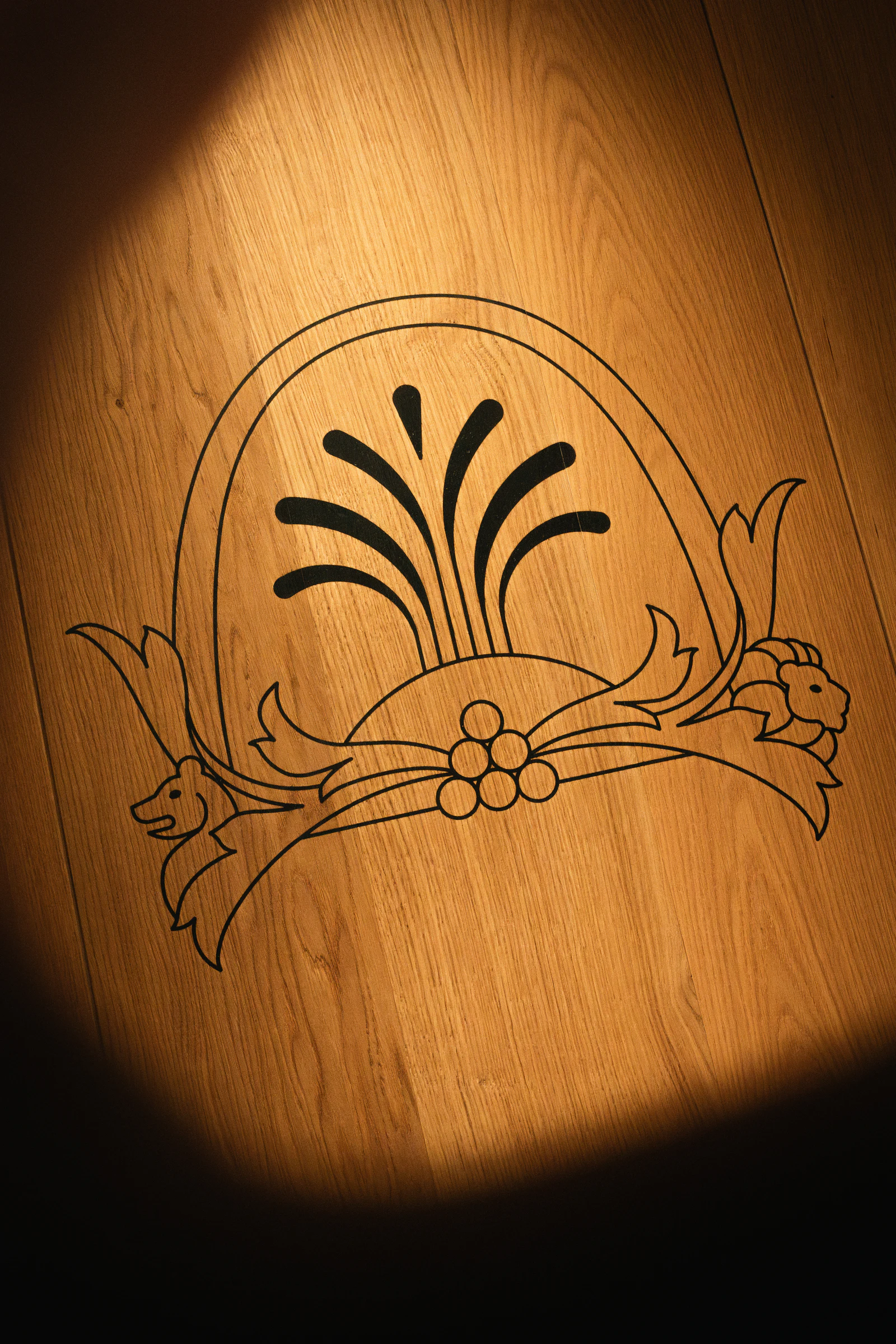 A carved Appenzell motif lit on a wooden wall