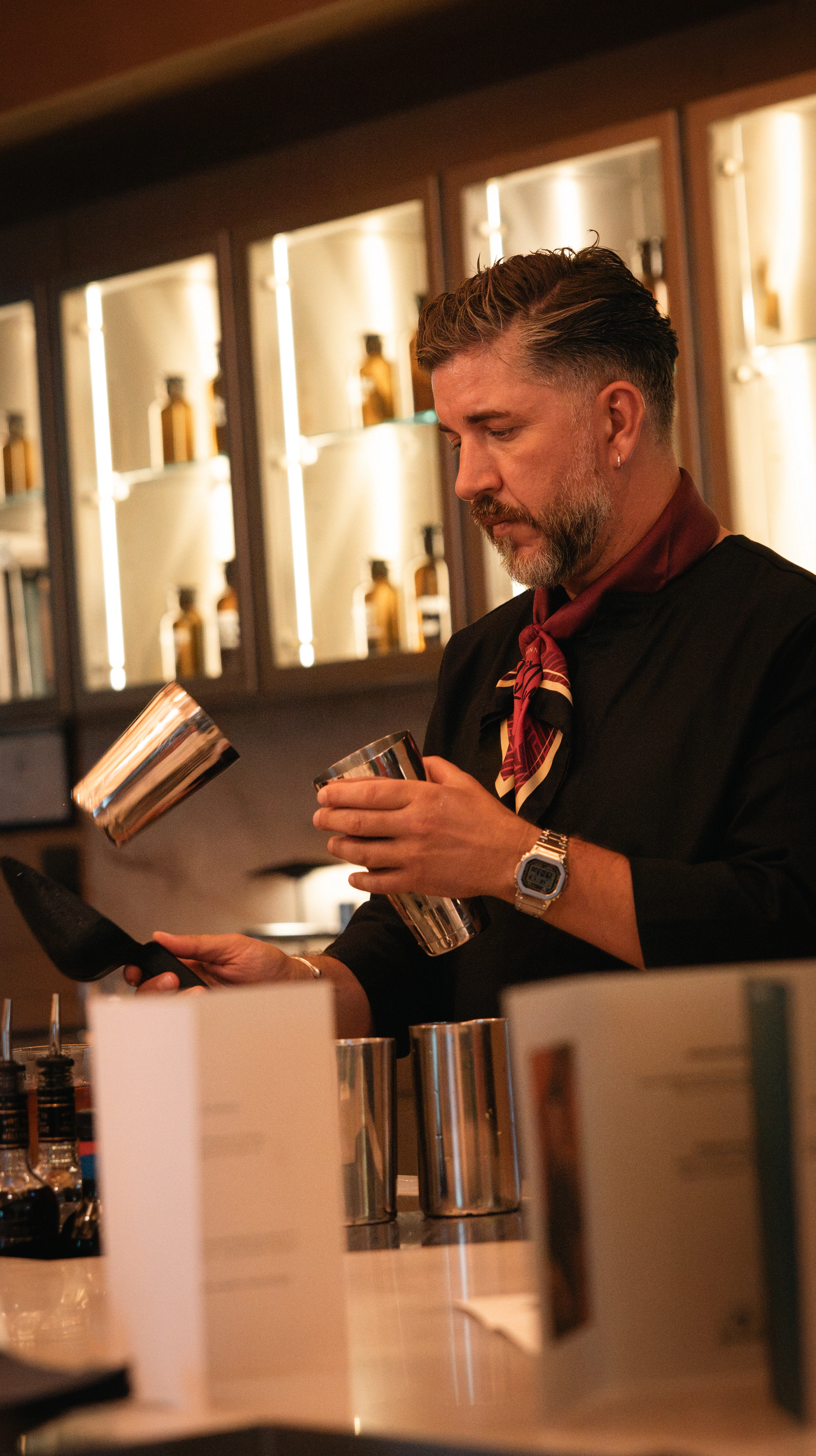 A bartender mixing behind the bar