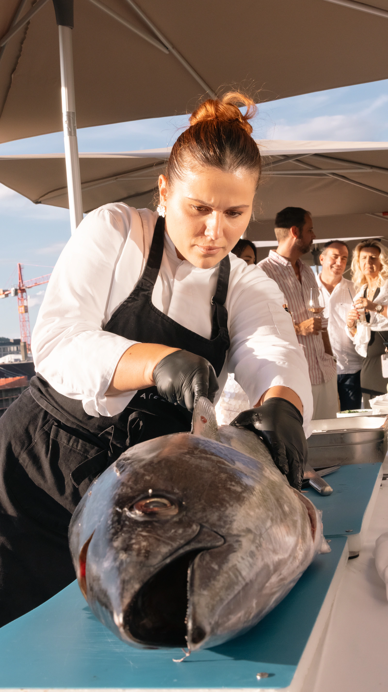 A chef breaking down a whole tuna on the pass