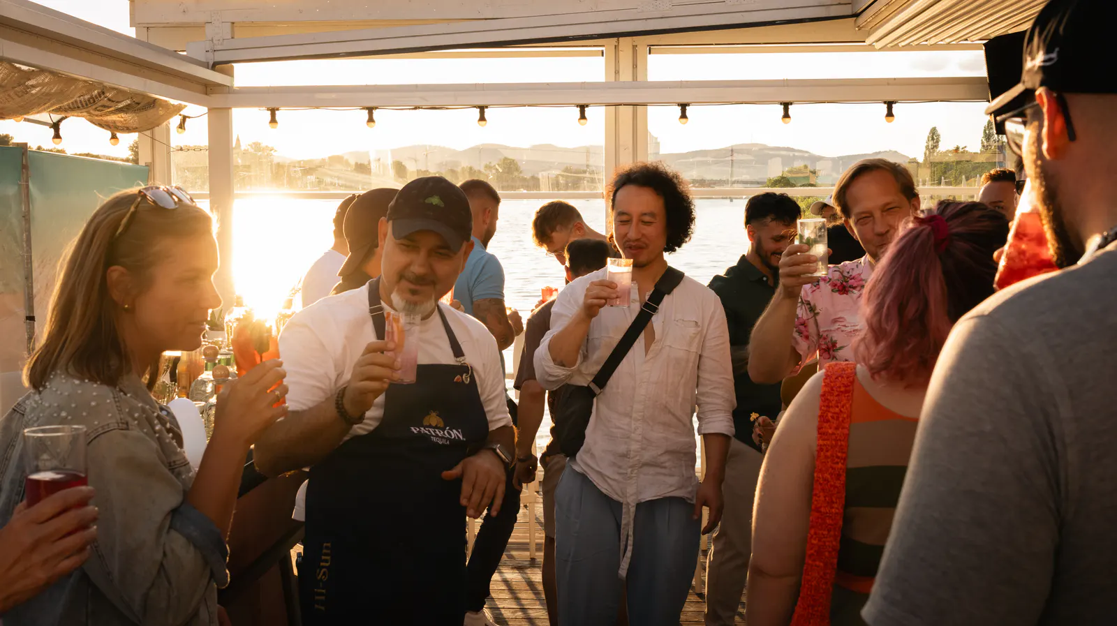 Guests in the low sun with drinks in hand