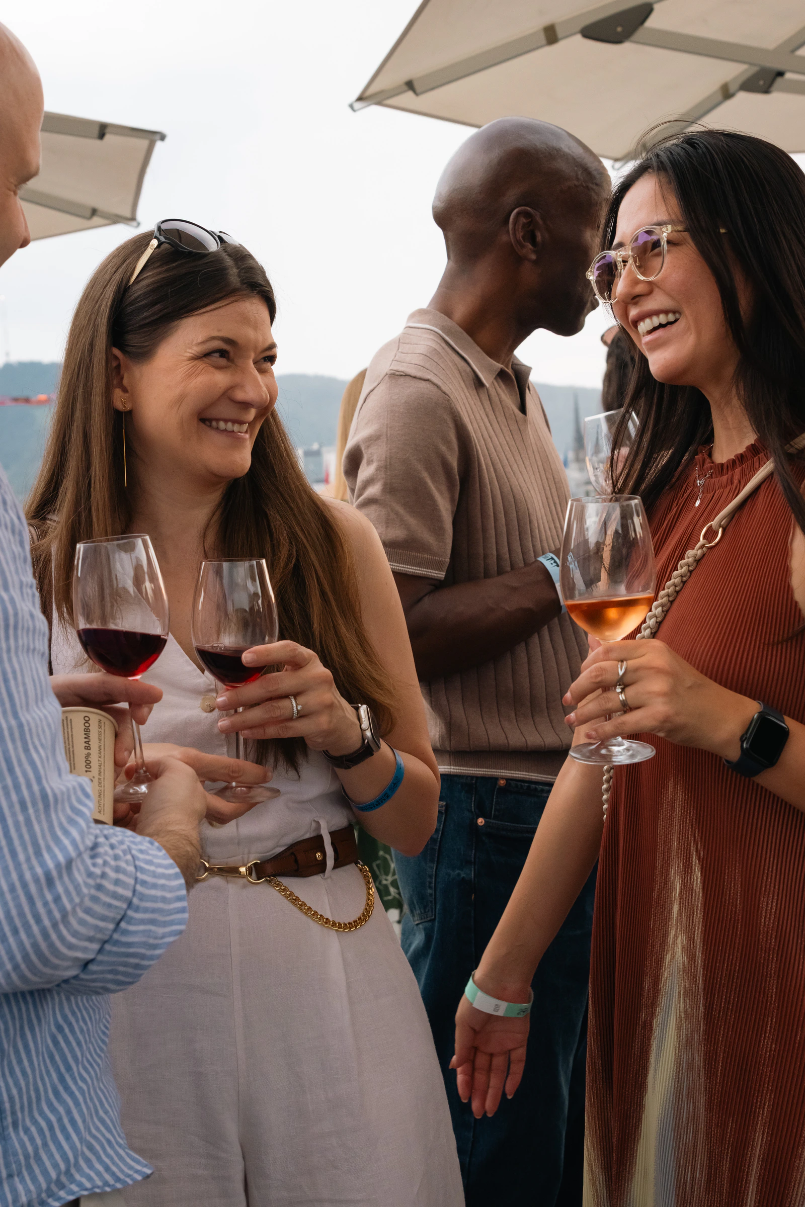 Two guests talking over red and orange wine under the rooftop parasols