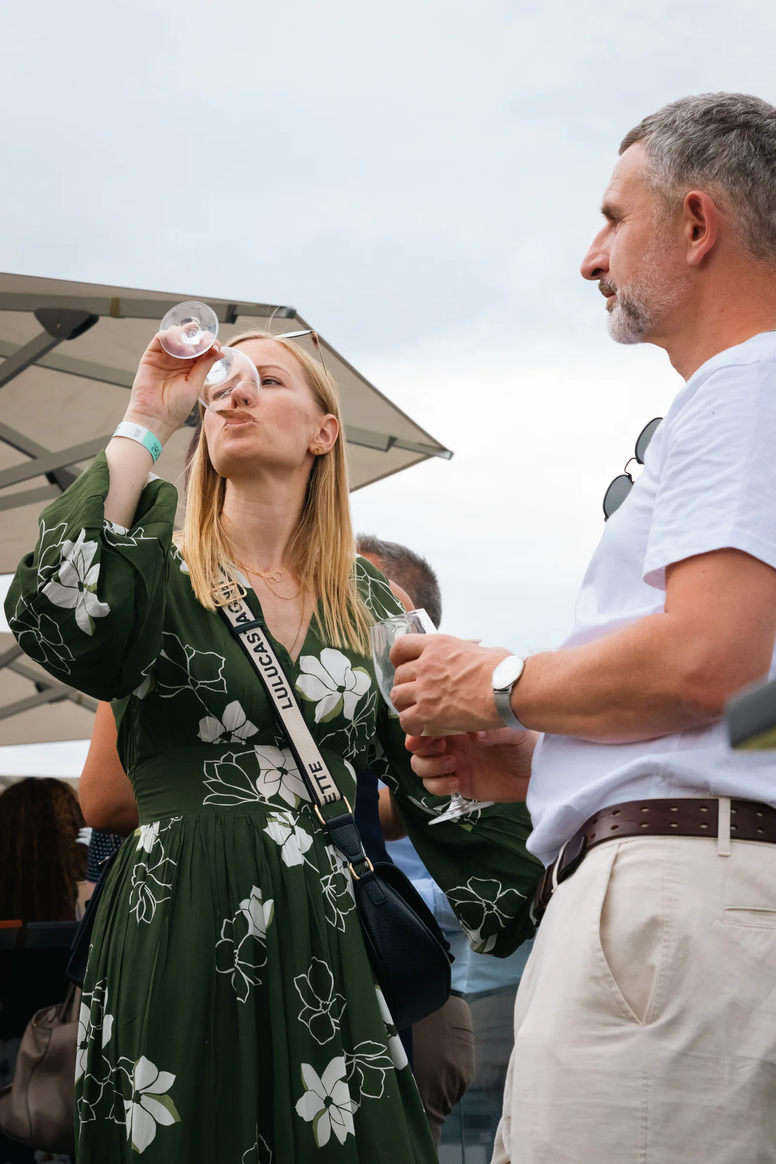 A guest tasting a pour beside the stand, glass to her lips